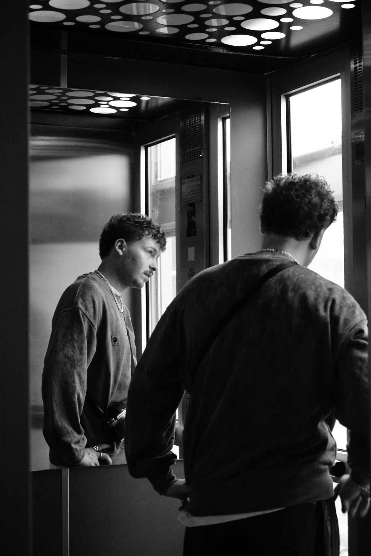 Autoportrait dans un miroir d'ascenseur, noir et blanc.